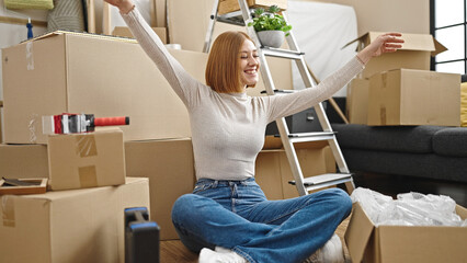 Young blonde woman smiling confident dancing on floor at new home