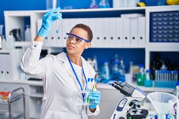 Fototapeta premium African american woman scientist holding test tubes at laboratory