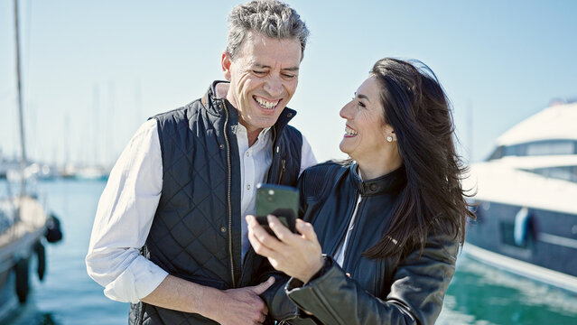 Senior man and woman couple smiling confident using smartphone at port