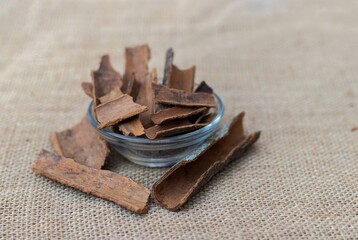 Closeup of Cinnamon Bark in a Glass Bowl Isolated on Burlap Fabric