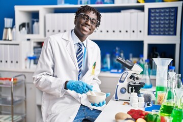 African american man scientist smiling confident mixing sample at laboratory