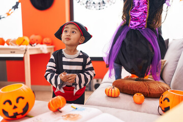 Adorable hispanic boy wearing pirate costume standing at home