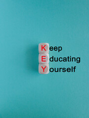 KEY, keep educating yourself symbol. Wooden cubes with red words 'KEY, keep educating yourself'....