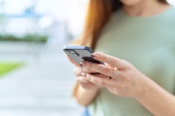 Young beautiful woman using smartphone at street