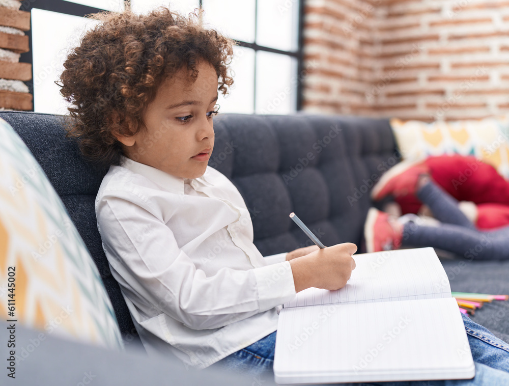 Poster african american boy preschool student sitting on sofa drawing on notebook at home