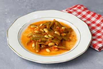 Homemade stewed green beans, tomatoes, garlic with olive oil. Zeytinyagli fasulye traditional food. Turkish cuisine.