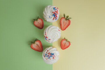 Cupcakes with strawberrie stand on a colored background. Next to the American flag