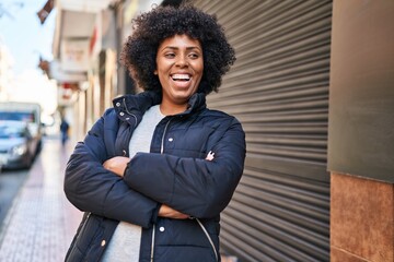 African american woman standing with arms crossed gesture at street