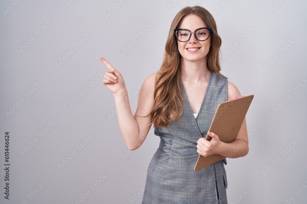 Poster caucasian woman wearing glasses and business clothes with a big smile on face, pointing with hand fi