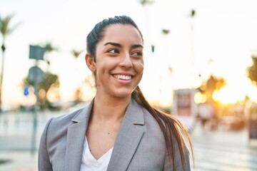 Young beautiful hispanic woman executive smiling confident looking to the side at street