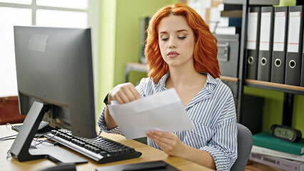 Young redhead woman business worker using computer opening envelope letter at office