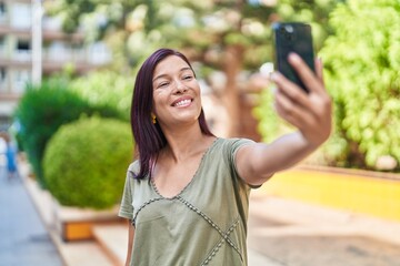 Young beautiful hispanic woman smiling confident making selfie by the smartphone at park