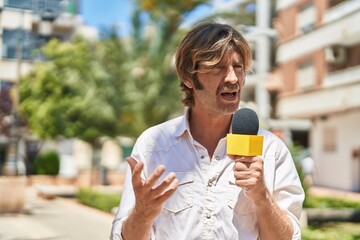 Young man reporter working using microphone at park
