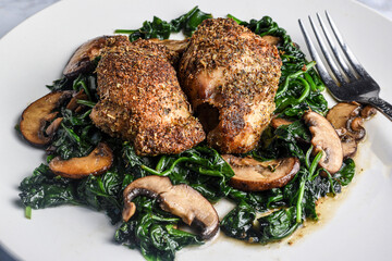 bone less chicken thighs  on sauteed spinach and  mushrooms