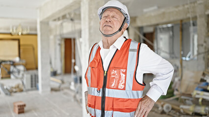 Senior grey-haired man architect stressed at construction site