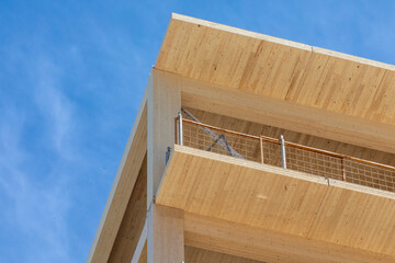 The wooden balconies and interior ceilings of a engineered timber multi story green, sustainable...