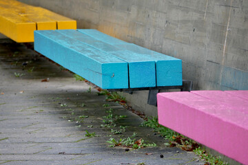 three colorful park benches on gray concrete