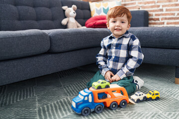 Adorable toddler playing with car toy sitting on floor at home