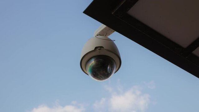 Clouds: Establishing Shot of a Round CCTV Camera Monitoring Building in Daylight
