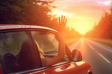 Travel waving her hand out of car to the sun at sunrise , Travel concept