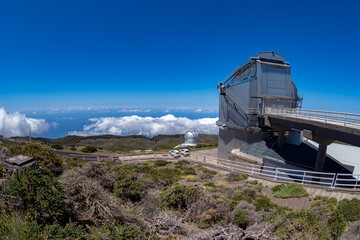 Obraz premium Large telescope at summit of mountain above the clouds 