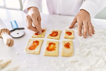 Young woman wearing cook uniform cooking pasta at kitchen
