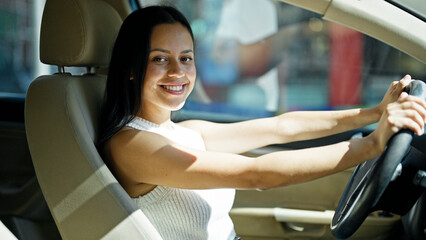 Young beautiful hispanic woman smiling confident driving car at street