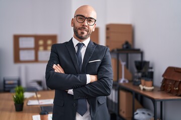 Young bald man business worker standing with arms crossed gesture at office