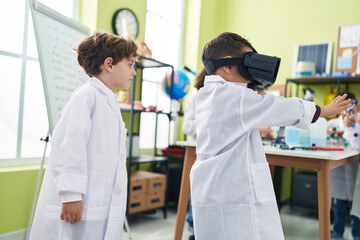 Obraz premium Adorable boys scientist student using virtual reality glasses at laboratory classroom