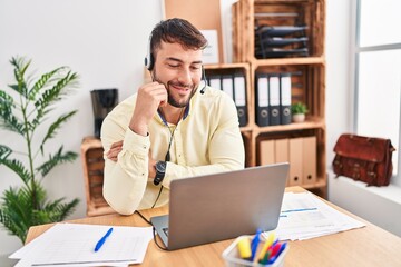 Naklejka premium Young hispanic man call center agent having video call at office