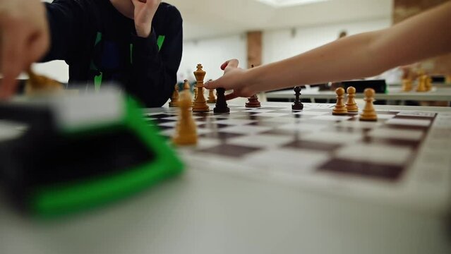 A close-up of a chessboard where children play fast chess.