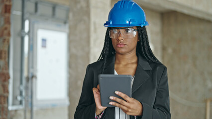 African american woman architect using touchpad thinking at construction site