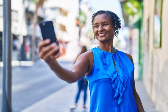 Middle age african american woman smiling confident making selfie by the smartphone at street