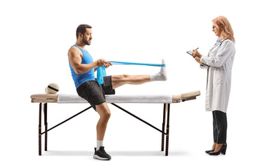 Obraz premium Man sitting on a therapy bed with a female doctor and exercising with a resistance band