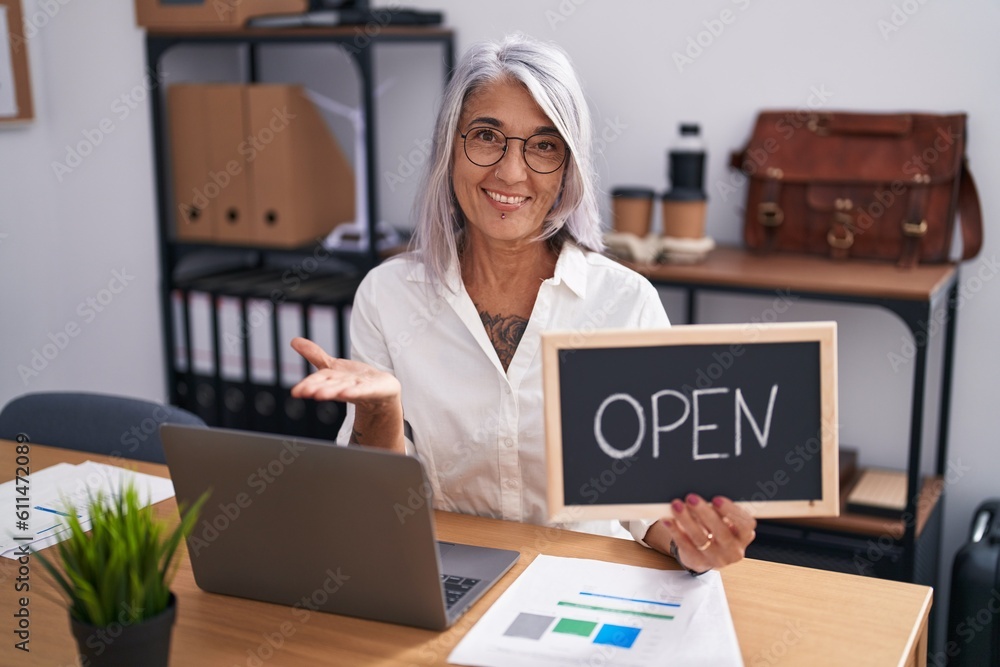 Canvas Prints Middle age woman with tattoos at the office holding blackboard with open word celebrating achievement with happy smile and winner expression with raised hand