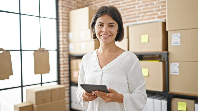 Young beautiful hispanic woman ecommerce business worker smiling confident using touchpad at office