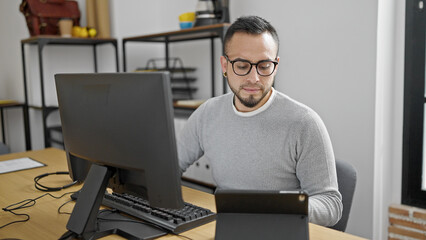 Hispanic man business worker using computer and tablet at office