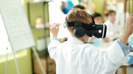 Adorable caucasian boy student using virtual reality glasses at laboratory classroom
