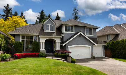 Home exterior during brilliant spring season with blooming flowers and trees plus lush green grass front lawn or yard