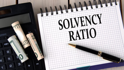 SOLVENCY RATIO - words in a notebook on the background of a calculator and banknotes