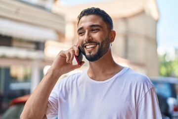 Young arab man smiling confident talking on the smartphone at street