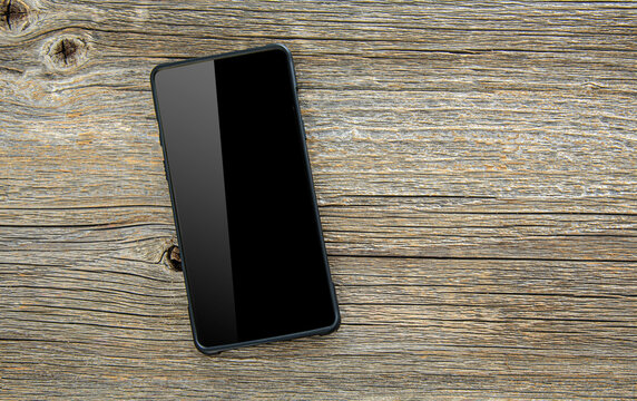 Black Smartphone On A Wooden Table.