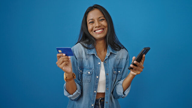 African American Woman Shopping With Smartphone And Credit Card Over Isolated Blue Background