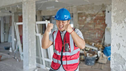  builder smiling with winner expression at construction site