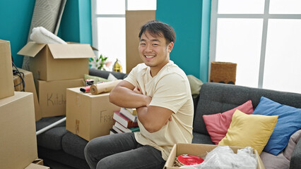  smiling confident sitting on sofa with arms crossed gesture at new home