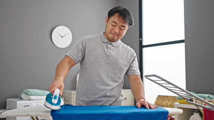 Obraz premium smiling confident ironing clothes at laundry room