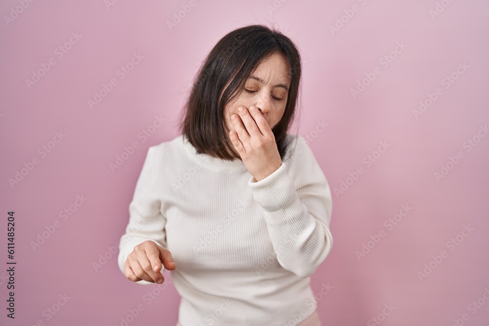 Sticker woman with down syndrome standing over pink background bored yawning tired covering mouth with hand.