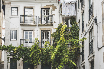 Fototapeta na wymiar Classic old apartment building with balconies and some drying clothes in Lisbon, Portugal