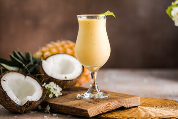 Pina colada pineapple cocktail or Lassi on a rustic wooden table - obrazy, fototapety, plakaty