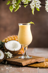 Pina colada pineapple cocktail or Lassi on a rustic wooden table